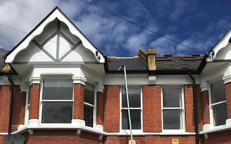 Gutter cleaning pole at the roofline of an Edwardian house